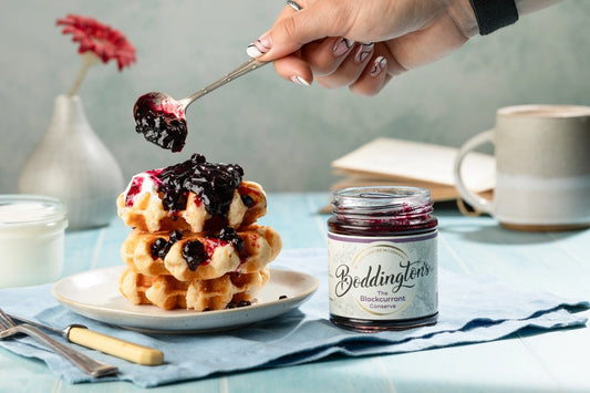 Stack of waffles being topped with Boddington's Blackcurrant Jam.
