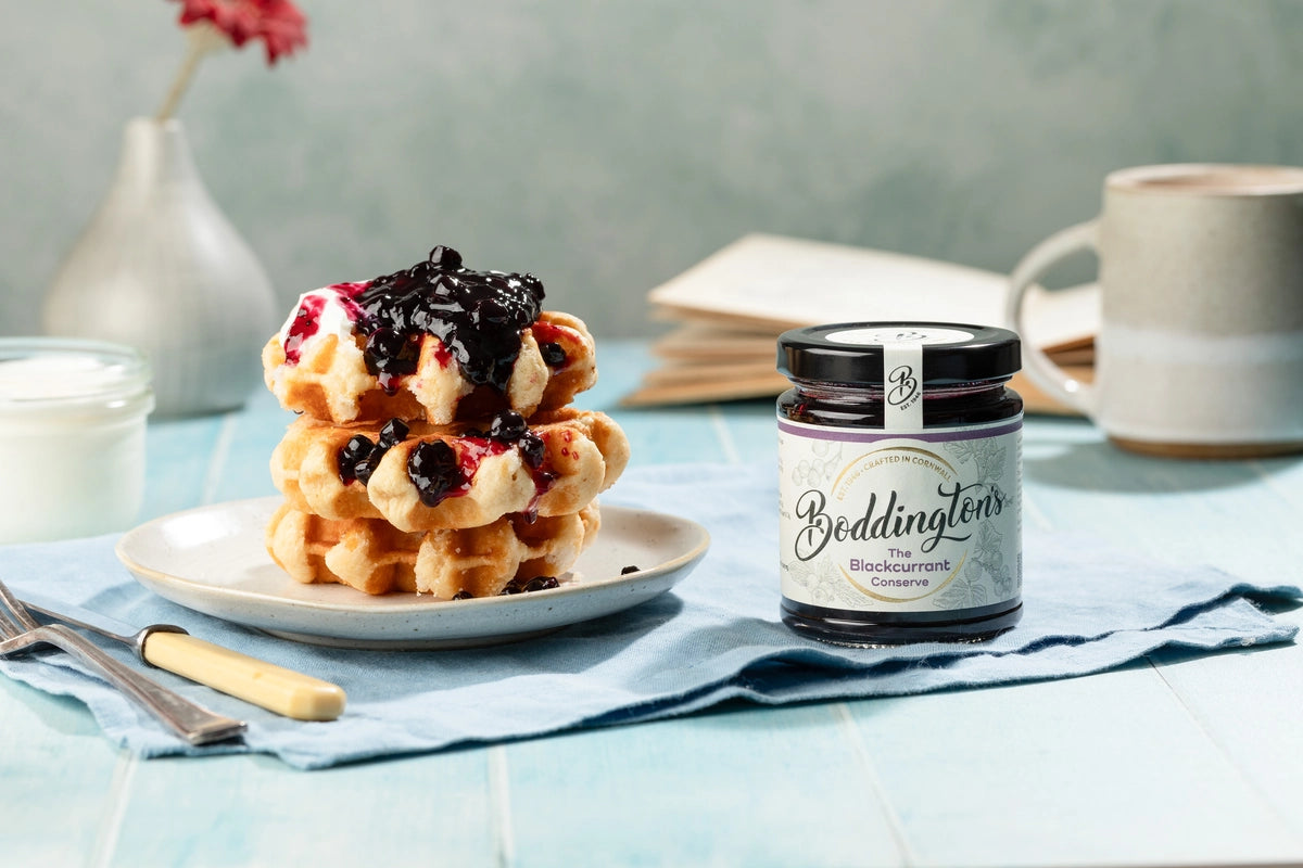 Stack of waffles with jam next to a jar of Boddington's Preserves.