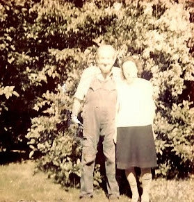 Vintage black and white photo of two people standing outdoors with trees in the background