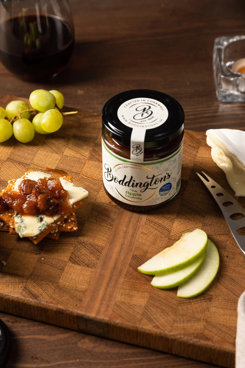 Jar of Beddington's chutney on a wooden board with appetizers